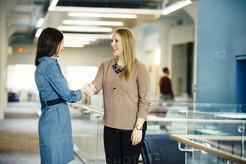 Caucasian businesswomen shaking hands in office