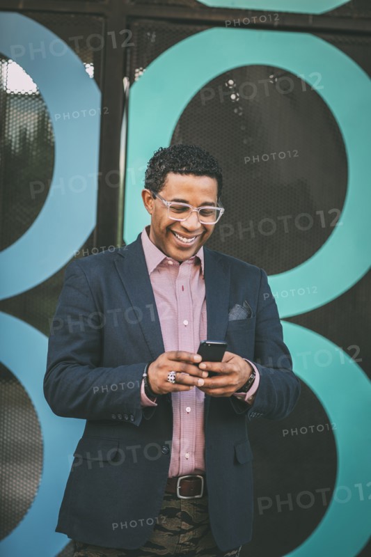 Mixed race businessman using cell phone outdoors