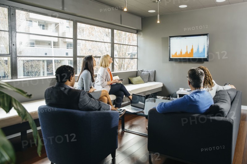 Business people watching presentation in office lounge