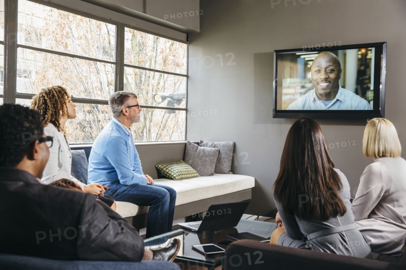 Business people watching teleconference in office meeting