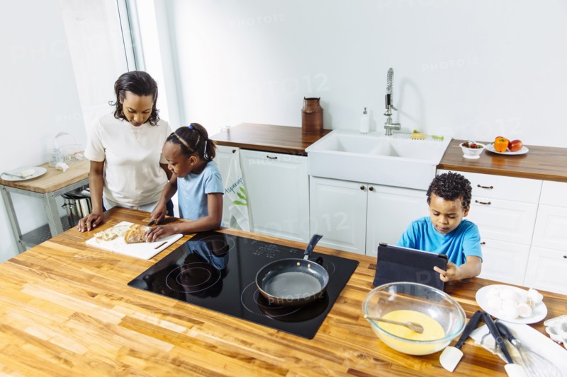 Family cooking breakfast together in kitchen