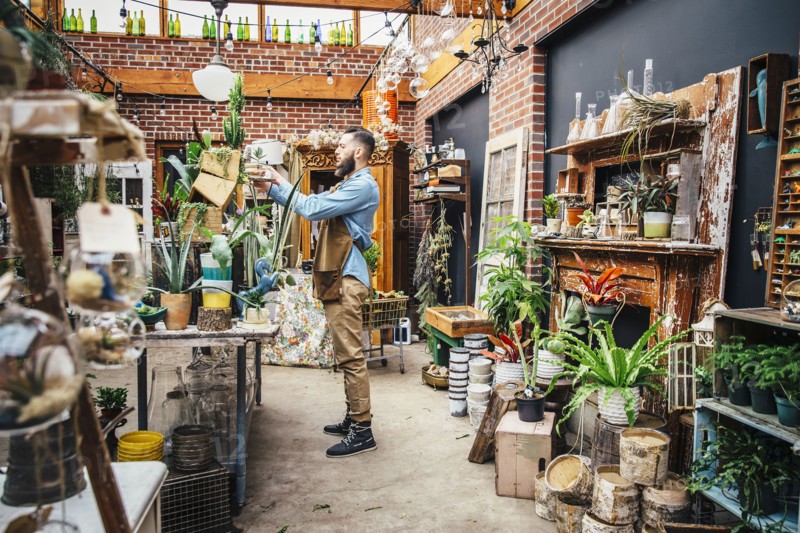 Caucasian employee watering plants in nursery