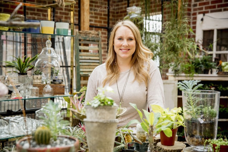 Caucasian employee smiling in plant nursery