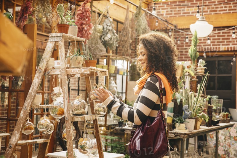 Mixed race customer examining plants in nursery