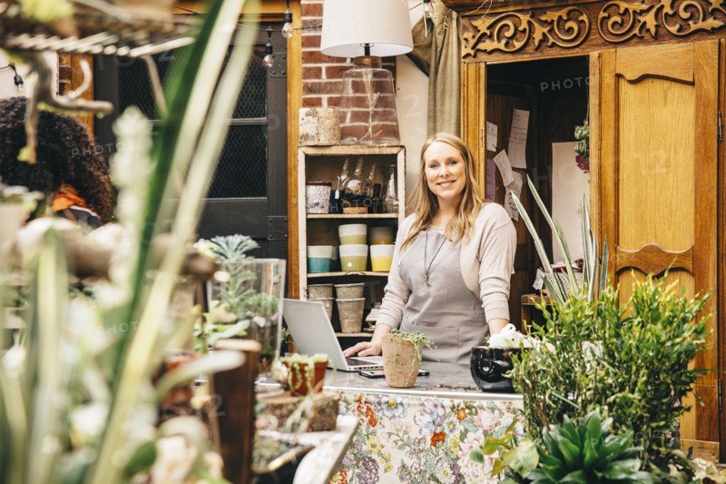 Caucasian employee using laptop in plant nursery