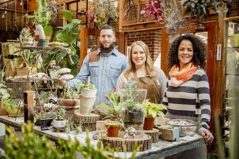 Employee and customers smiling in plant nursery