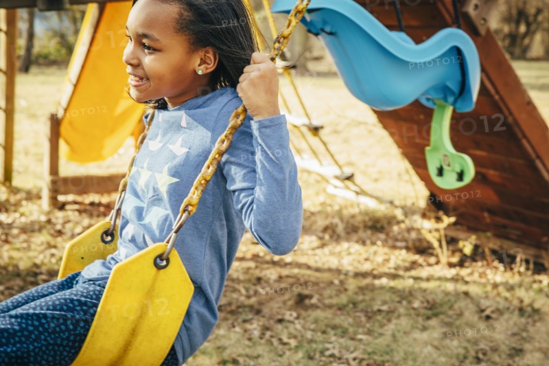 Black girl sitting on swing set