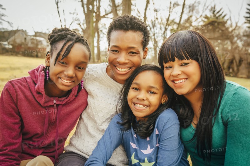 Black mother and daughters sitting outdoors