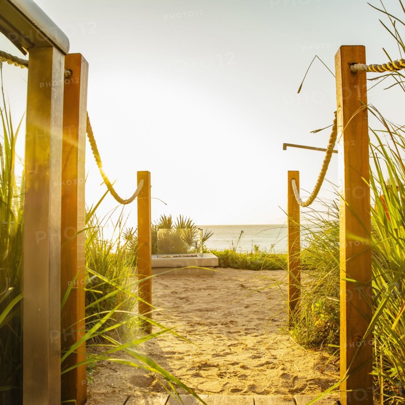 Walkway to beach under blue sky