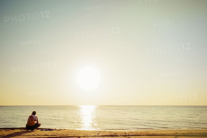 Mixed race man sitting on beach
