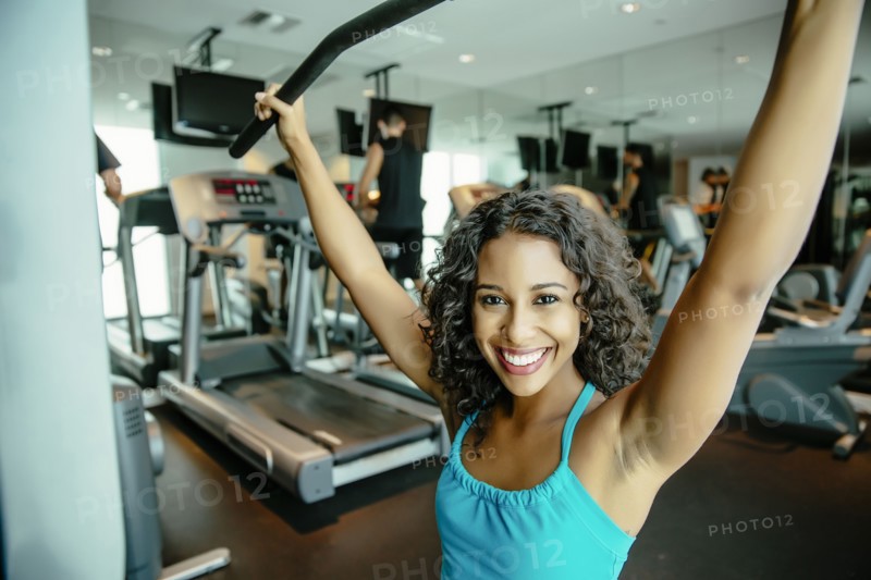 Woman using exercise machine in gymnasium
