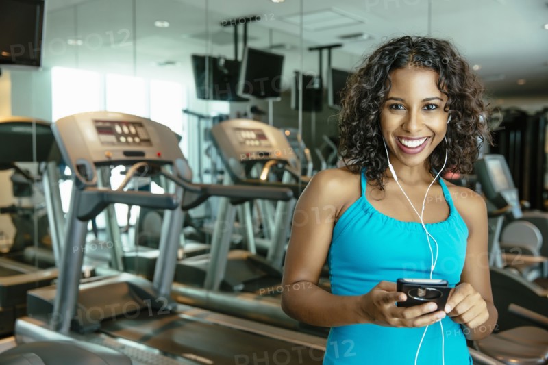 Woman listening to earbuds in gymnasium