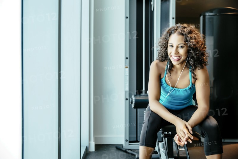 Woman sitting on exercise machine in gymnasium