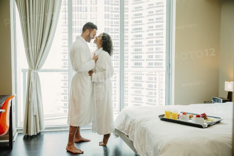 Couple hugging in bathrobes in hotel room