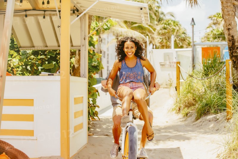 Couple riding bicycle on beach