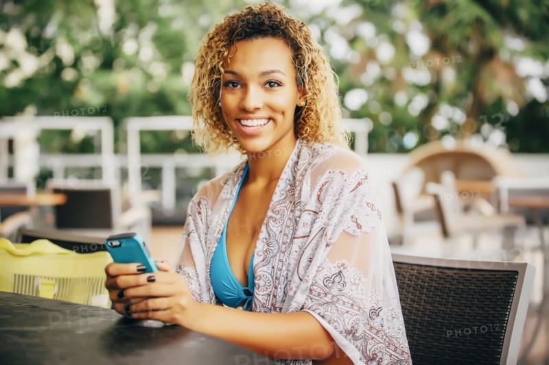 Mixed race teenager using cell phone at table