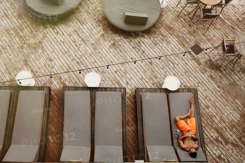 Aerial view of man laying on deck chair