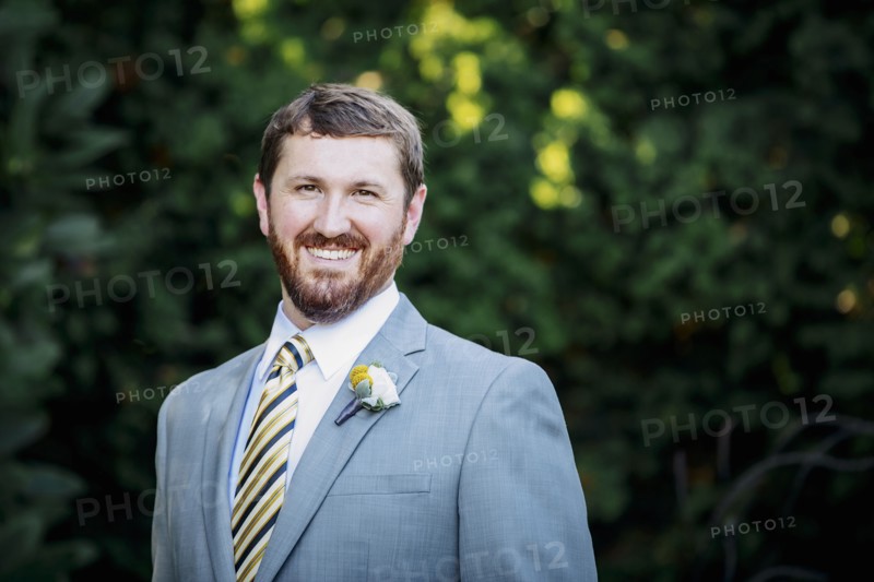 Caucasian groom smiling in garden