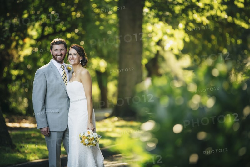 Caucasian bride and groom hugging on rural road