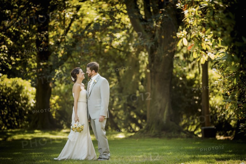 Caucasian bride and groom walking in grass