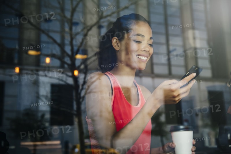 Mixed race woman using cell phone in cafe