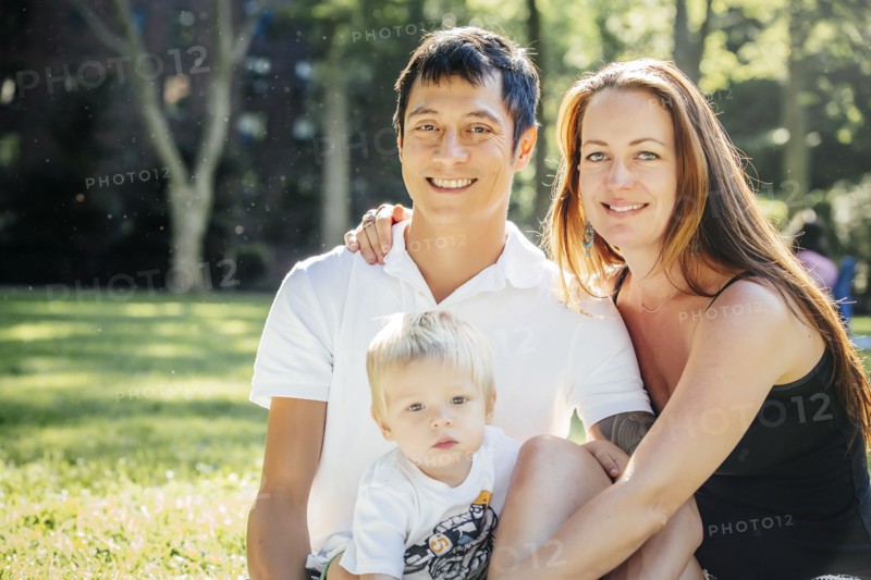 Smiling family sitting on grass in park
