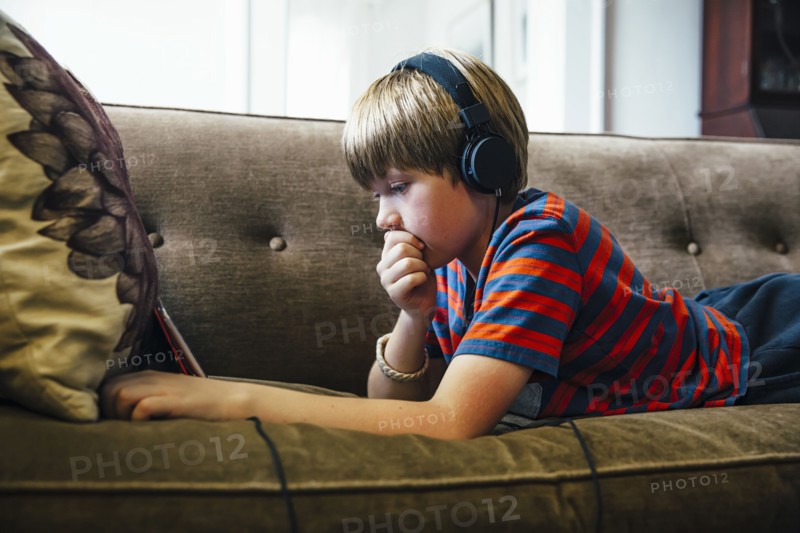 Caucasian boy using digital tablet on sofa