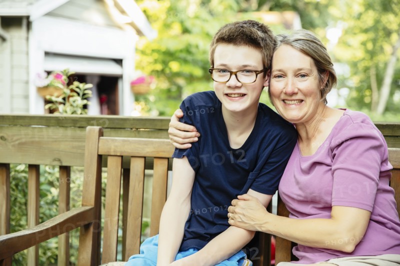 Caucasian grandmother and grandson smiling in backyard