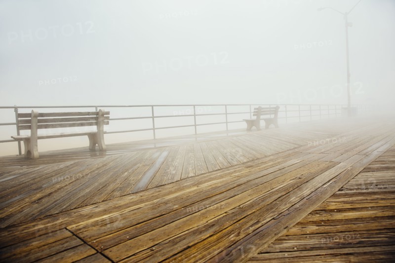 Fog over benches on wooden boardwalk