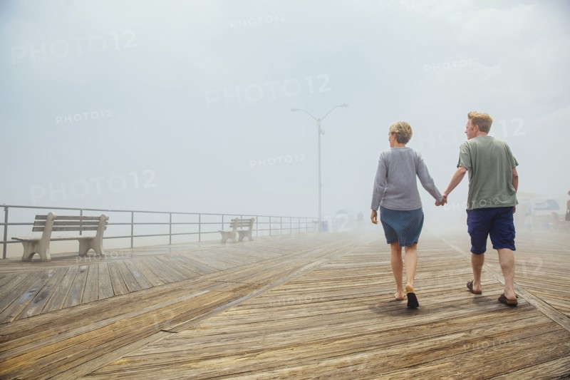 Couple holding hands on wooden boardwalk