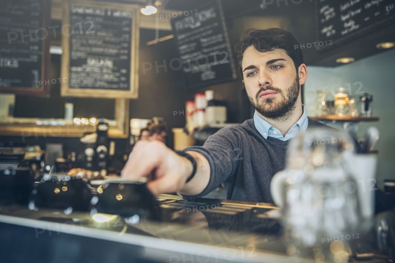 Caucasian barista making coffee in cafe