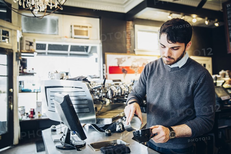 Caucasian barista making coffee in cafe