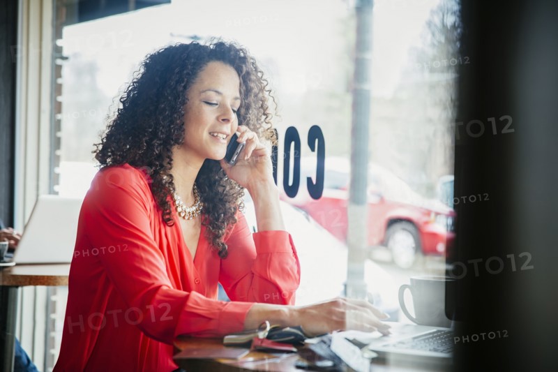 Businesswoman talking on cell phone in cafe