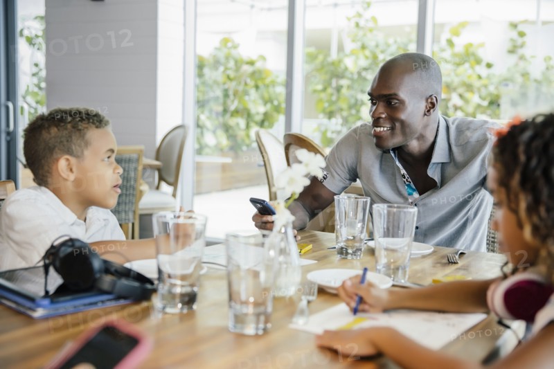 Father and children eating in restaurant