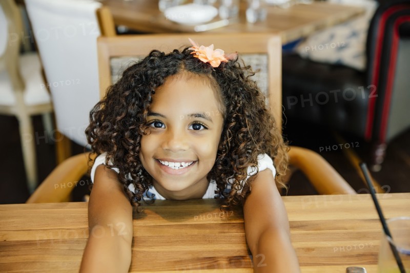 Mixed race girl sitting at restaurant table