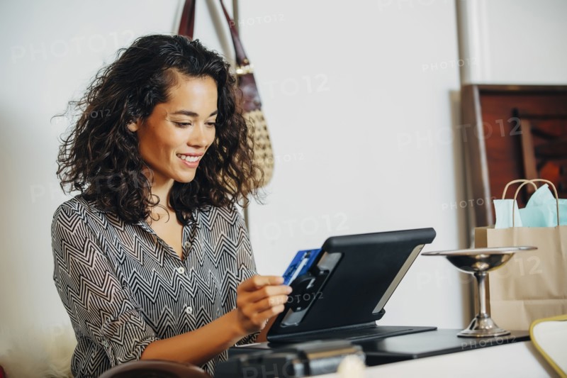 Mixed race clerk swiping credit card at register