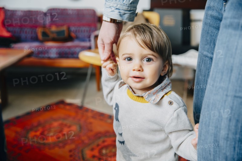 Caucasian mother helping baby son walk