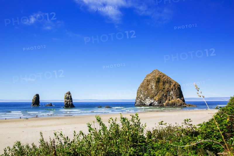 Sea stack rocks on beach under blue sky