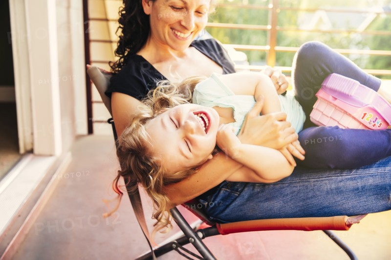 Caucasian mother and daughter playing on patio