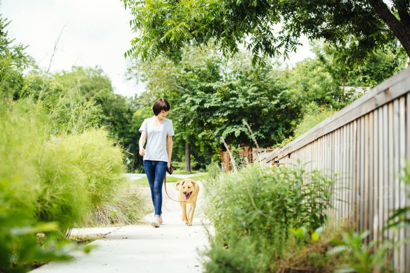 Caucasian woman walking dog in park