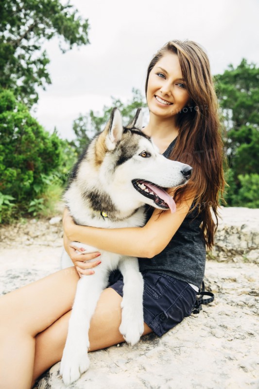 Caucasian woman petting dog outdoors