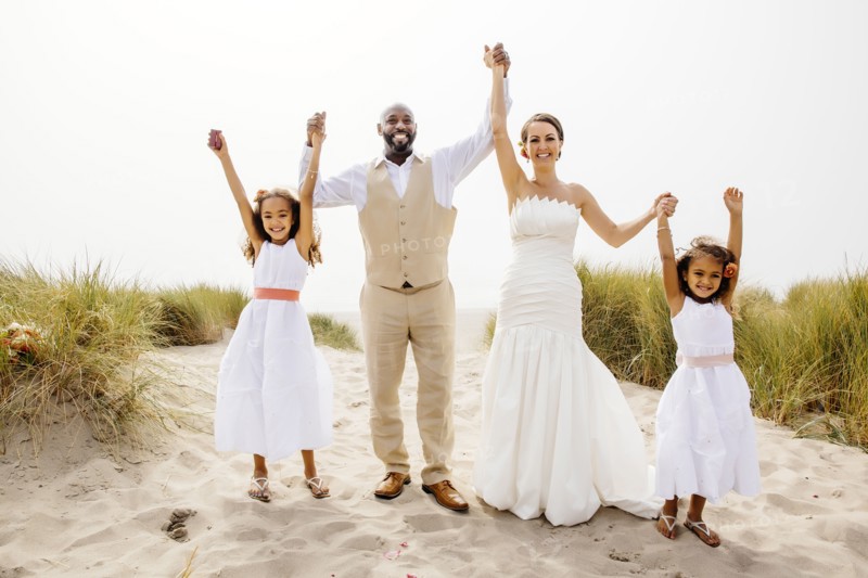 Bride and groom cheering with flower girl daughters