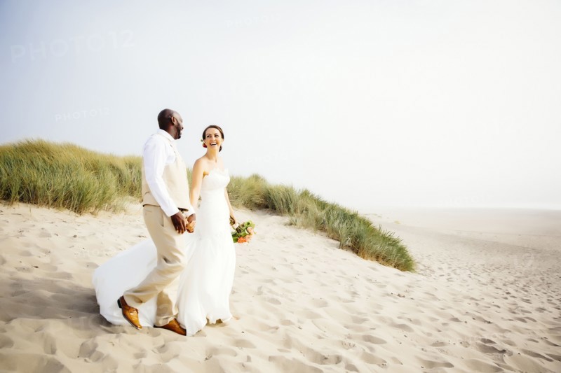 Newlywed couple walking on beach