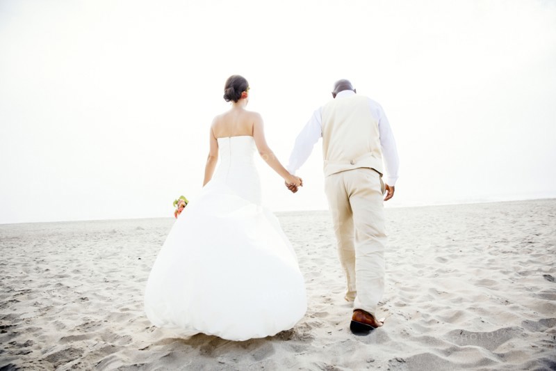 Newlywed couple walking on beach