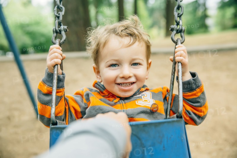 Caucasian mother pushing son on swing