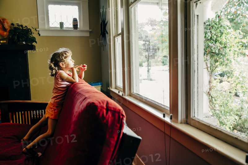 Caucasian girl looking out window