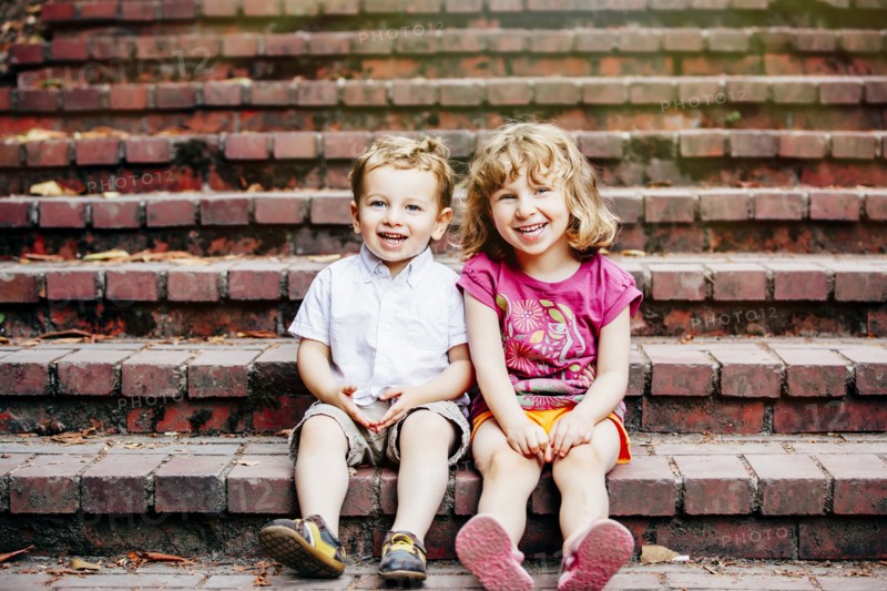 Caucasian children sitting on steps