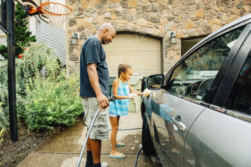 Father and daughter washing car