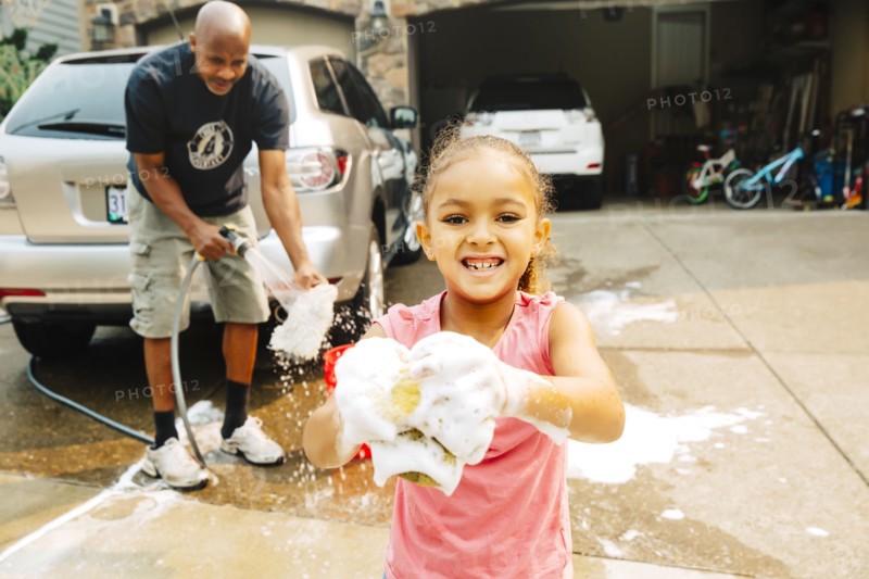 Father and daughter washing car