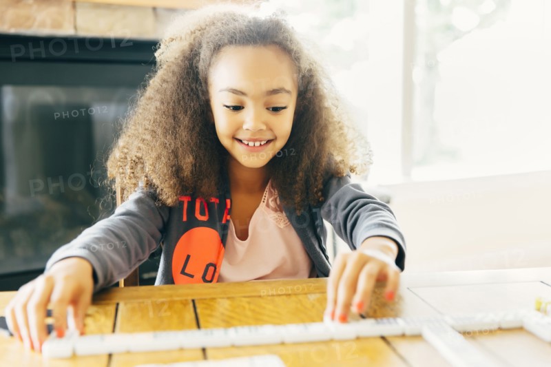 Mixed race girl playing with dominoes